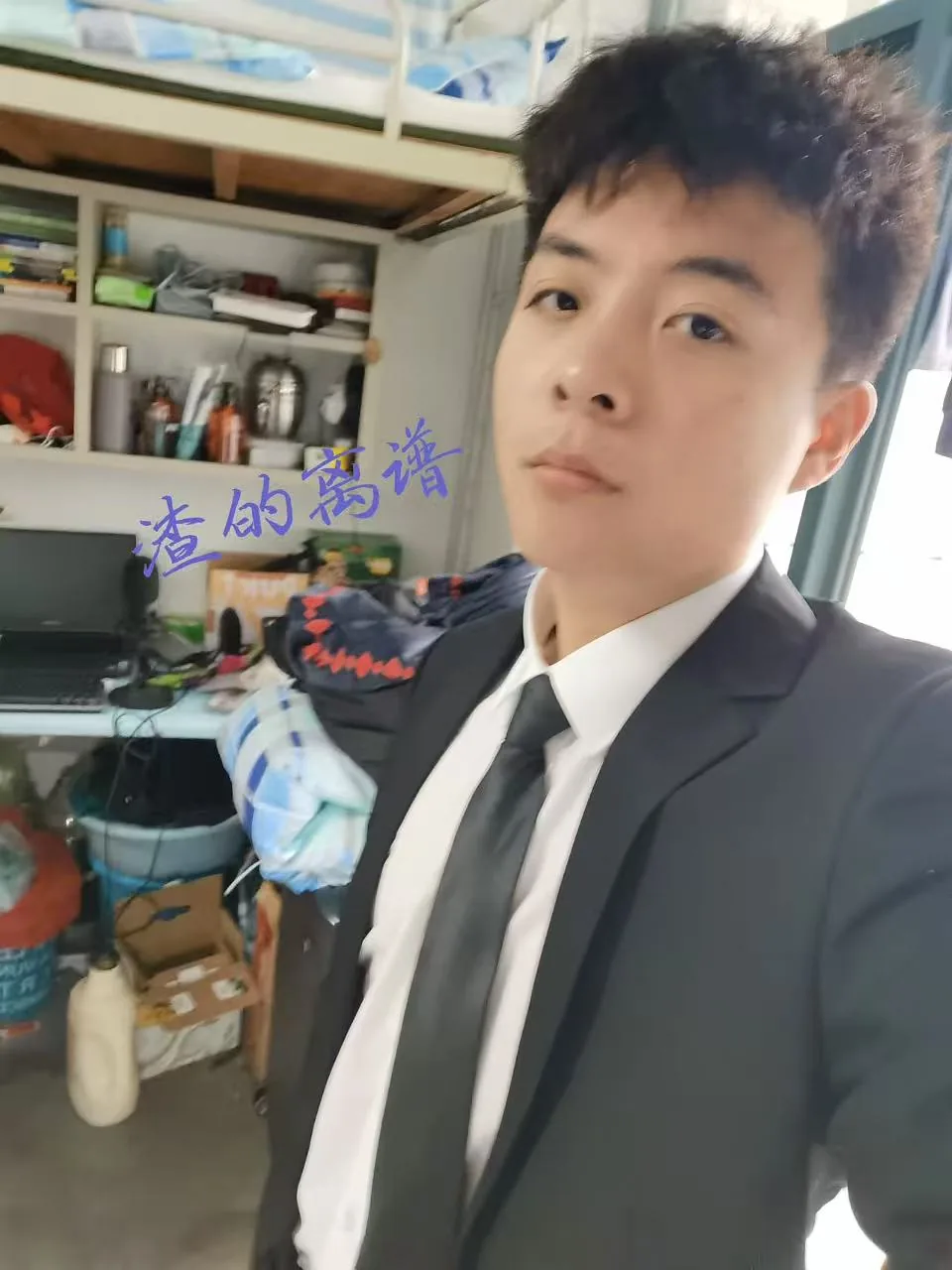 身穿深色西装的室内自拍，背景为房间陈设